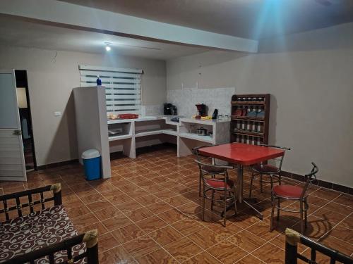 a kitchen with a red table and a refrigerator at Estancia kv in Coatepec