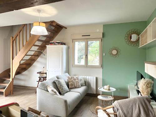 a living room with a couch and a staircase at La Maison Agoméa in Saint-Georges-sur-Cher