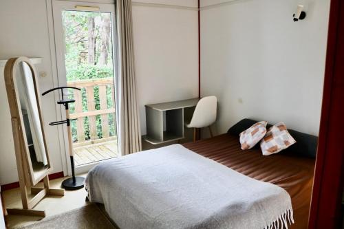 a bedroom with a bed and a large window at Le Havre de Paix Chalet in Rivières