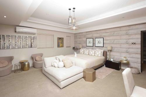 a bedroom with a white bed and a white couch at Luxe Life House in Sheffield Beach