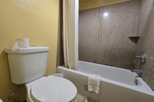 a bathroom with a toilet and a tub and a sink at Sunrise Inn By OYO Newport News US-60 in Stoney Brook Estates
