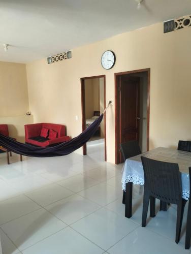 a room with a hammock and a table and a clock at PAULIN Surf in Montañita