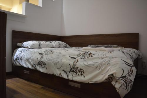 a bedroom with a bed with a wooden headboard at Studium Green Apartman in Cluj-Napoca
