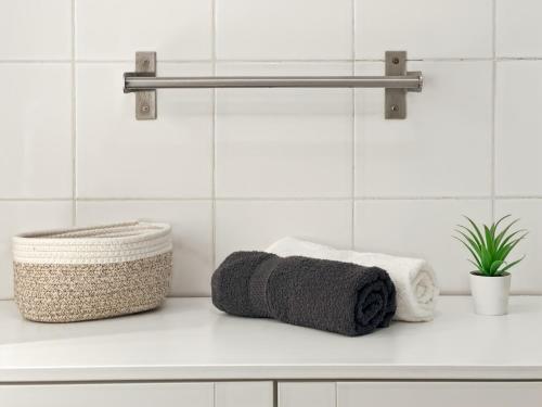 a white bathroom with towels on a counter at Le Cosy Saint-Cyr in Saint-Cyr-lʼÉcole