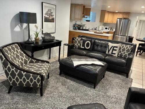 a living room with a leather couch and a chair at The Wrigleyville Garden 200 Steps to Wrigley-2BR in Chicago