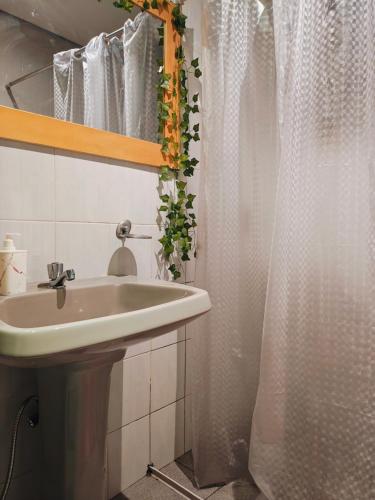 a bathroom with a sink and a shower curtain at Vila Urban Hostel ॐ Jardins in São Paulo