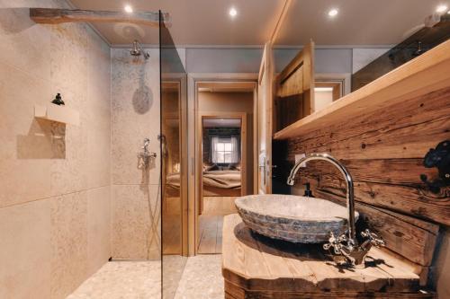 a bathroom with a stone sink and a shower at Alpenchalet Reit im Winkl in Reit im Winkl