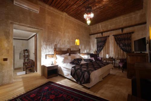 a bedroom with a bed and a television in a room at Hikmet's House in Avanos