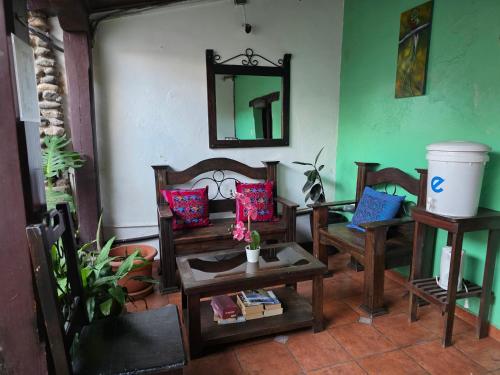 ein Wohnzimmer mit Stühlen, einem Tisch und einem Spiegel in der Unterkunft Casa Nikté in Antigua Guatemala