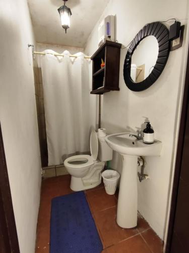 ein Badezimmer mit Toilette, Waschbecken und Spiegel in der Unterkunft Casa Nikté in Antigua Guatemala
