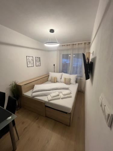 a bedroom with a bed with white sheets and a window at Apartmán Ella - Riegrova 41 in Děčín