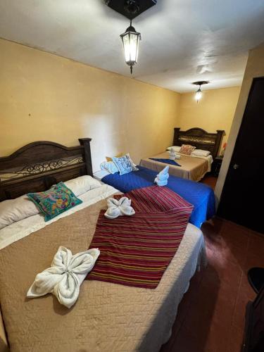 ein Hotelzimmer mit zwei Betten mit Schleifen darauf in der Unterkunft Casa Nikté in Antigua Guatemala