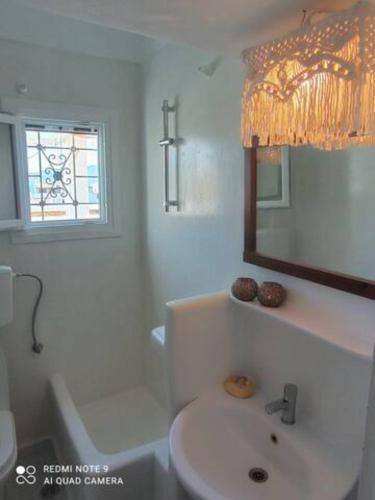 a white bathroom with a sink and a mirror at Debbie's Apartments in Adamantas