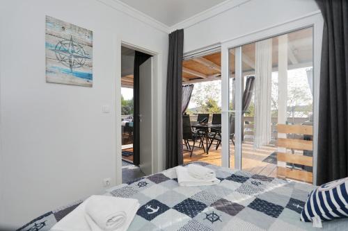 a bedroom with a bed and a view of a patio at Ahoi Hause 10 Strandhaus mit Meerblick & privatem Zugang in Drage