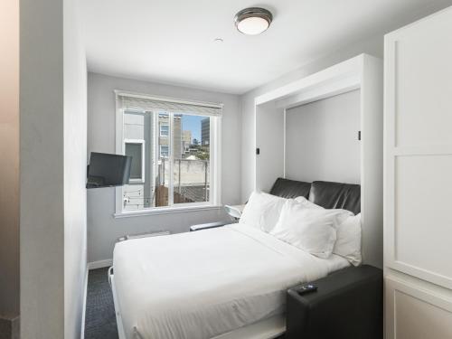 a bedroom with a white bed and a window at The Dorel SF in San Francisco