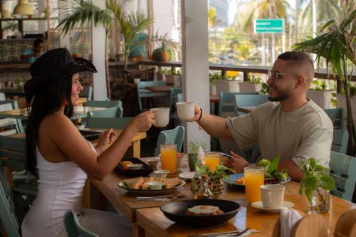 a man and woman sitting at a table drinking coffee at Hotel Barahona Cartagena in Cartagena de Indias