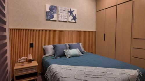 a bedroom with a bed with blue sheets and a night stand at Beach Loft Style and Beach Heated Pool in Mazatlán