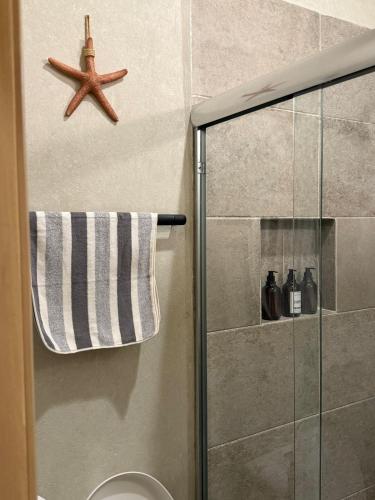 a bathroom with a shower with a starfish on the wall at Beach Loft Style and Beach Heated Pool in Mazatlán