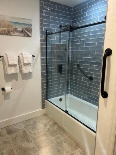 a bathroom with a glass shower with blue tiles at Beautiful view from a peaceful place in St. George Island