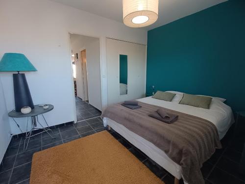 a bedroom with a large bed and a blue wall at La Bella Vista - appartement classé 2 étoiles in Mèze