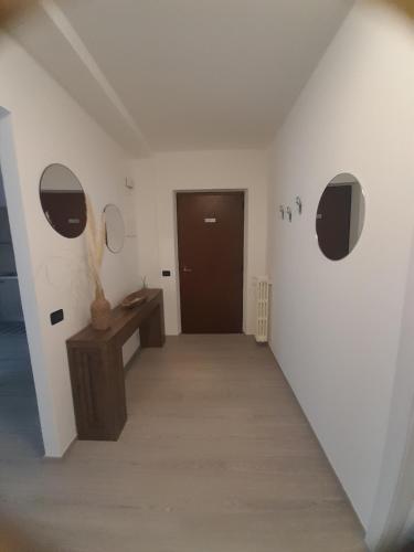 a hallway with two round mirrors and a door at Casa Vacanza dei Nonni in Varzo