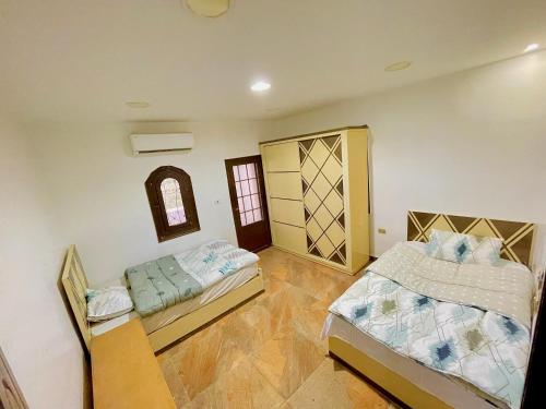 a bedroom with two beds and a door in it at Yellow House on the Nile in Luxor