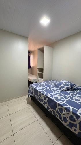 a bedroom with a bed with a blue and white comforter at Pousada Rafael in Juazeiro do Norte