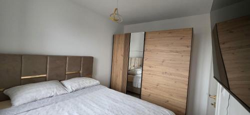 a bedroom with a bed and a large wooden door at Splendida in Bosanska Gradiška