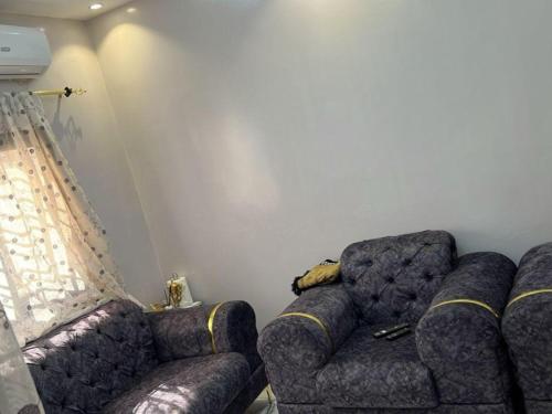 un salon avec un canapé, un fauteuil et une fenêtre dans l'établissement Studio Meublé, à Rufisque