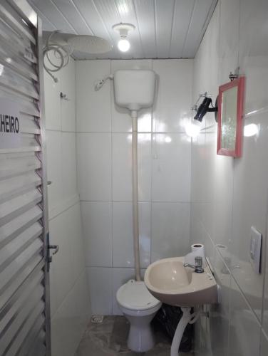 a white bathroom with a toilet and a sink at Quarto pra OITO 8 Pessoas in Ouro Preto