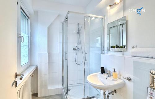 a white bathroom with a shower and a sink at BEGE APARTMENTS CitySleep in Aachen