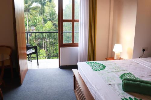 a bedroom with a bed and a view of a balcony at The kandy downtown in Katugastota
