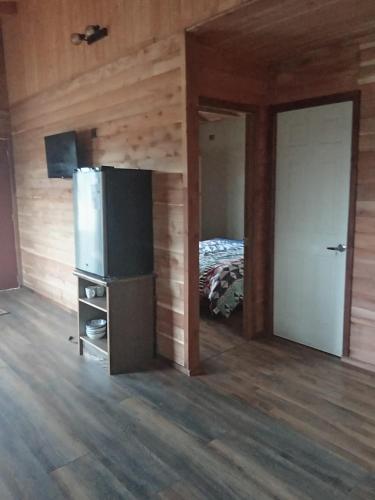 a room with a refrigerator and a bedroom with a bed at Casa acogedora in Castro