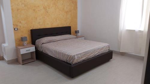 a bedroom with a bed and a nightstand with a bed sidx sidx sidx sidx at Alisia Apartment in Rossano Stazione