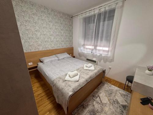 a bedroom with a bed with two white towels on it at Apartman Mireli in Zlatibor