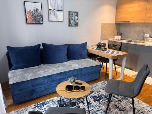 a living room with a blue couch and a table at Apartman Mireli in Zlatibor