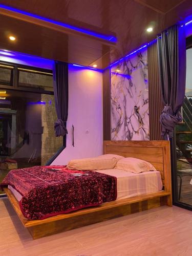 a bedroom with a large bed with purple lights at HOUSEBOAT AFFA grup in Karanganyar