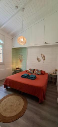 a bedroom with a large bed with a red blanket at Villa Ulutawu in Le François
