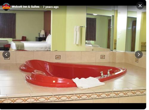 a red bath tub in a hotel room at Wolcott inn and suites in Wolcott