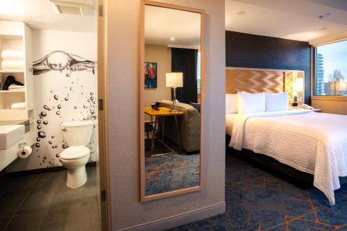 a hotel room with a bed and a toilet at Blue Horizon Hotel in Vancouver