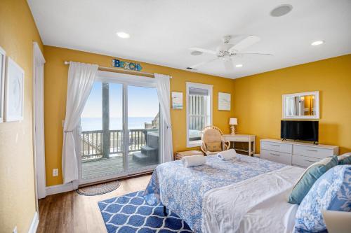 a bedroom with a bed and a balcony at NTB3886 Soulshine-Sunshine-Moonshine in North Topsail Beach