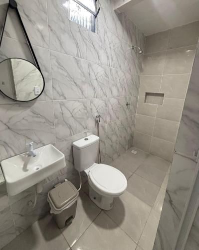 a bathroom with a toilet and a sink and a mirror at Pousada Sol Nascente in Morros