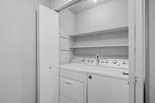 a white laundry room with a washer and dryer at Cozy Downtown Stone Mountain Apartment in Stone Mountain