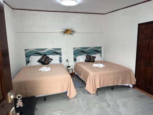 two beds in a room with two beds sidx sidx sidx sidx at Virginia's apartaments in Omoa