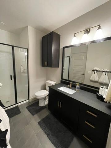 a bathroom with a toilet and a sink and a mirror at Deep Ellum Lux in Dallas