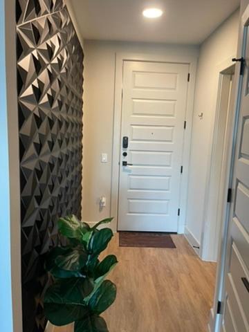 a hallway with a white door and a plant at Deep Ellum Lux in Dallas