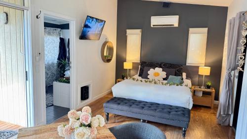 a bedroom with a bed and a bench in a room at Couple's Spa Retreat Resort Villa with complimentary champagne upon arrival in Cowes