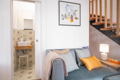 a living room with a blue couch and stairs at Portas da Villa in Miranda do Douro