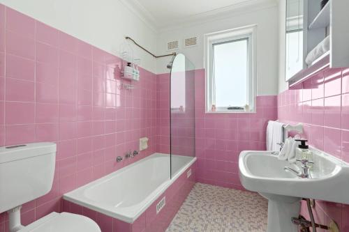a pink bathroom with a toilet and a sink at Shoreleaf Haven - Moments from Waves & Seaside Eats in Deewhy