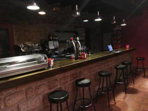 un bar con sgabelli neri in un ristorante di Racó dels Torrats a Torre del Compte
